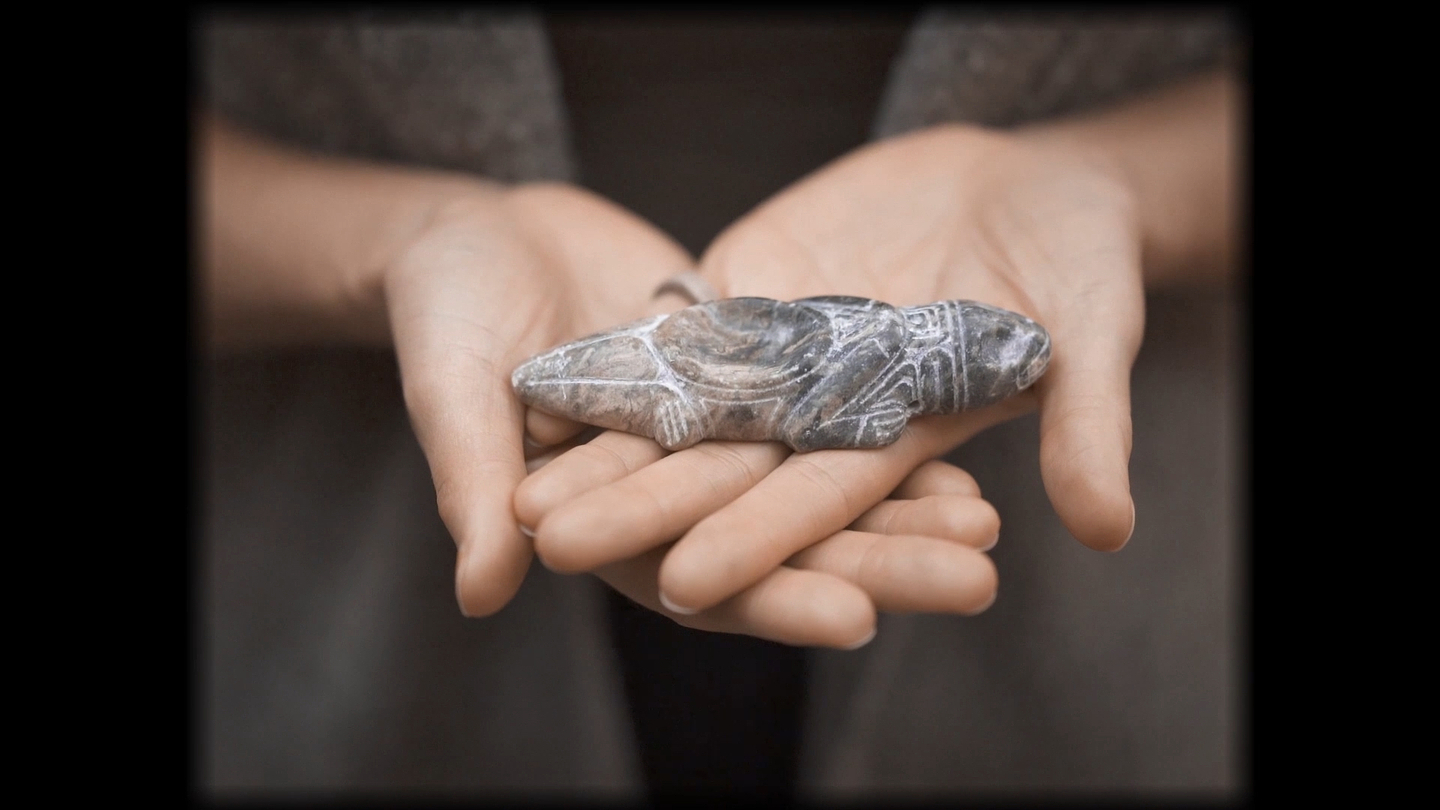 A Taíno ceremonial object held in open palms.