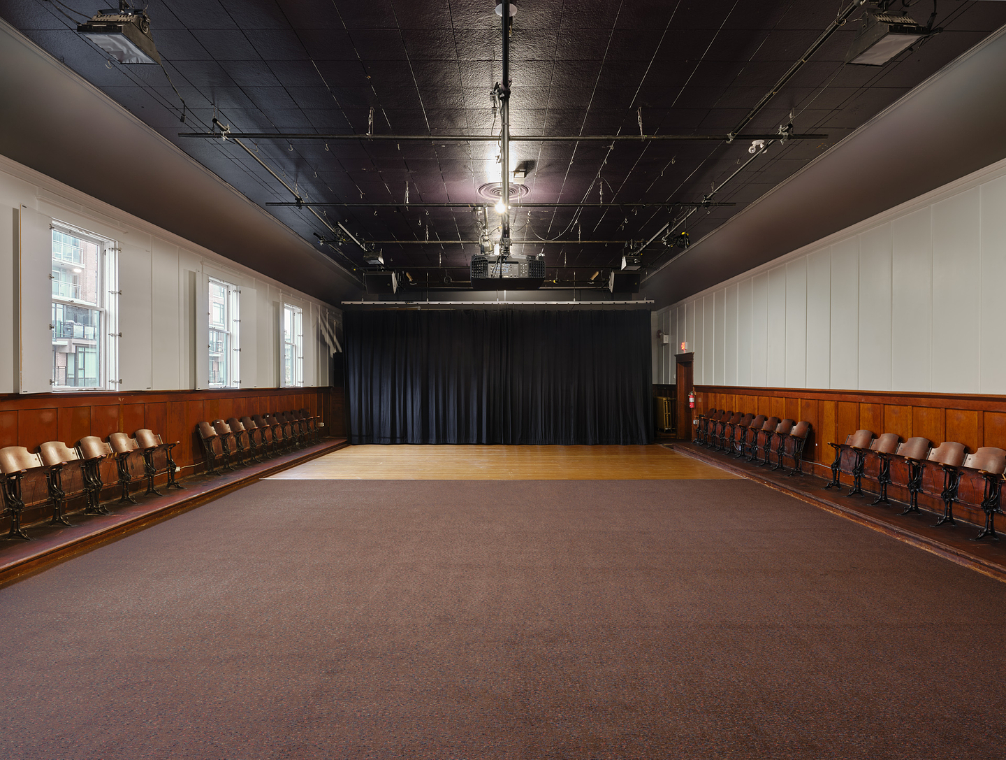 A colour photograph of Western Front’s Grand Luxe Hall. The room is empty and a black curtain hangs across the back wall.